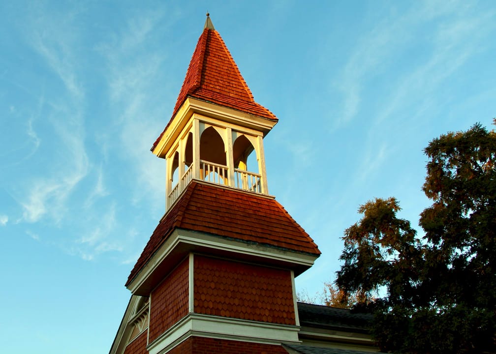Close-up of the Auburn University Chapel's shingled belfry and steeple against a clear fall sky, November 2019.