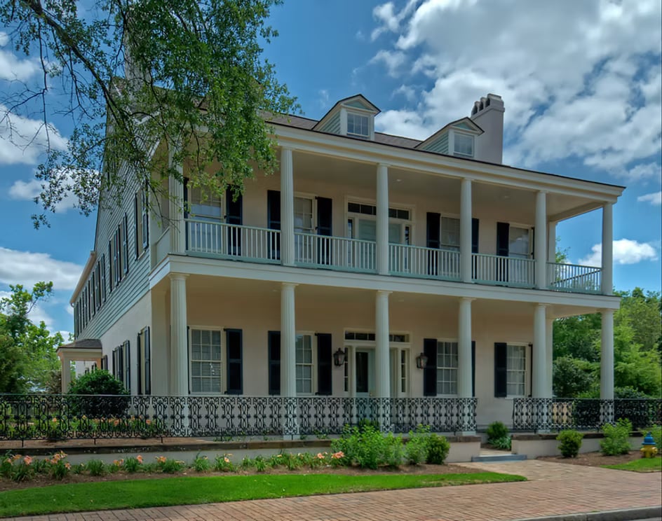 Exterior of the 1836 Fort Condé Inn, a historic boutique inn in Mobile, Alabama, with white columned facade