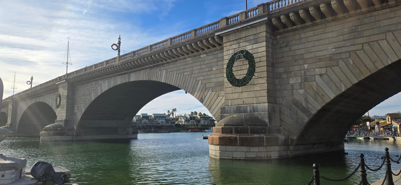 A close architectural view of two of the bridge's granite arches, with a commemorative wreath medallion on the central pier.