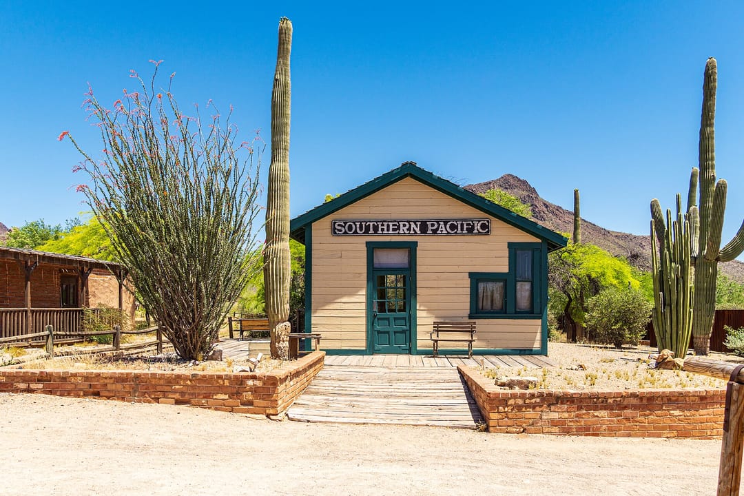 The "Southern Pacific" railway depot set building at Old Tucson Studios, Tucson, Arizona, flanked by saguaro cacti.