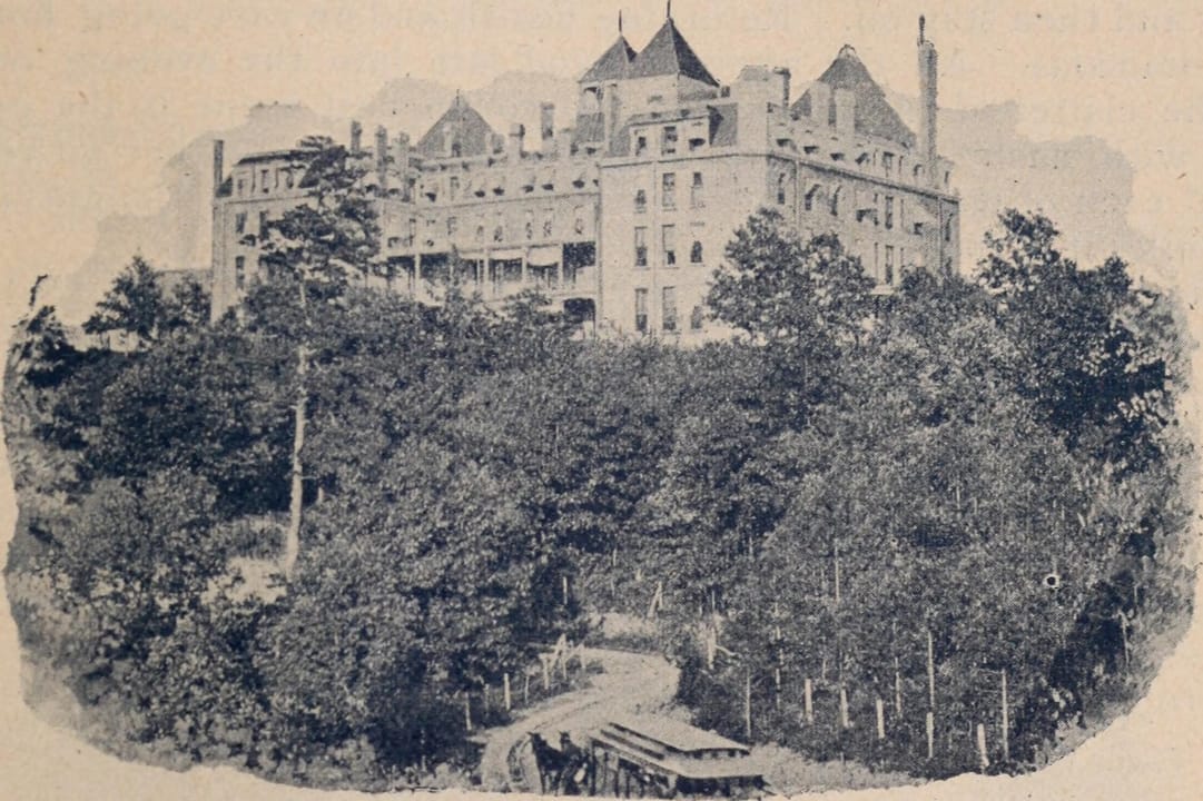 A halftone view of the Crescent Hotel on its wooded hilltop with the approach road and a horse-drawn car in the foreground, from an 1897 journal.