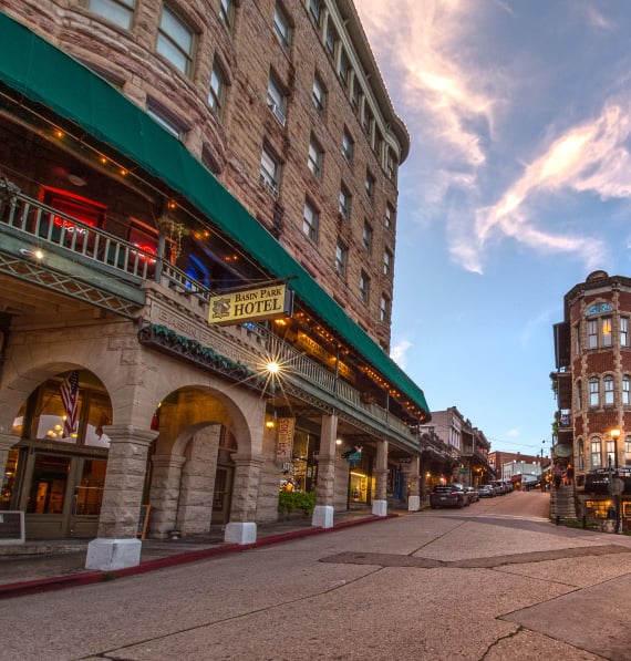 Exterior of the seven-story limestone 1905 Basin Park Hotel in downtown Eureka Springs, Arkansas, built into a hillside so every floor opens at ground level