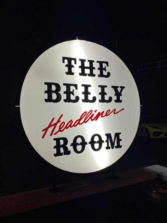 Illuminated sign for the Belly Room, one of the Comedy Store's named performance rooms, photographed inside the venue.