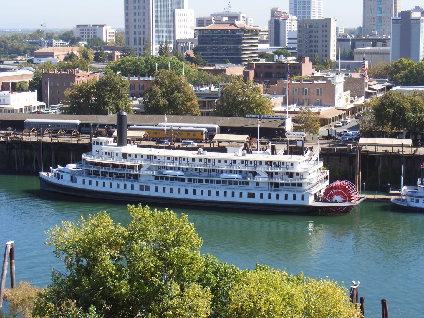 The Delta King sternwheel riverboat with its red paddlewheel and white superstructure permanently moored along the Sacramento River in Old Sacramento, California