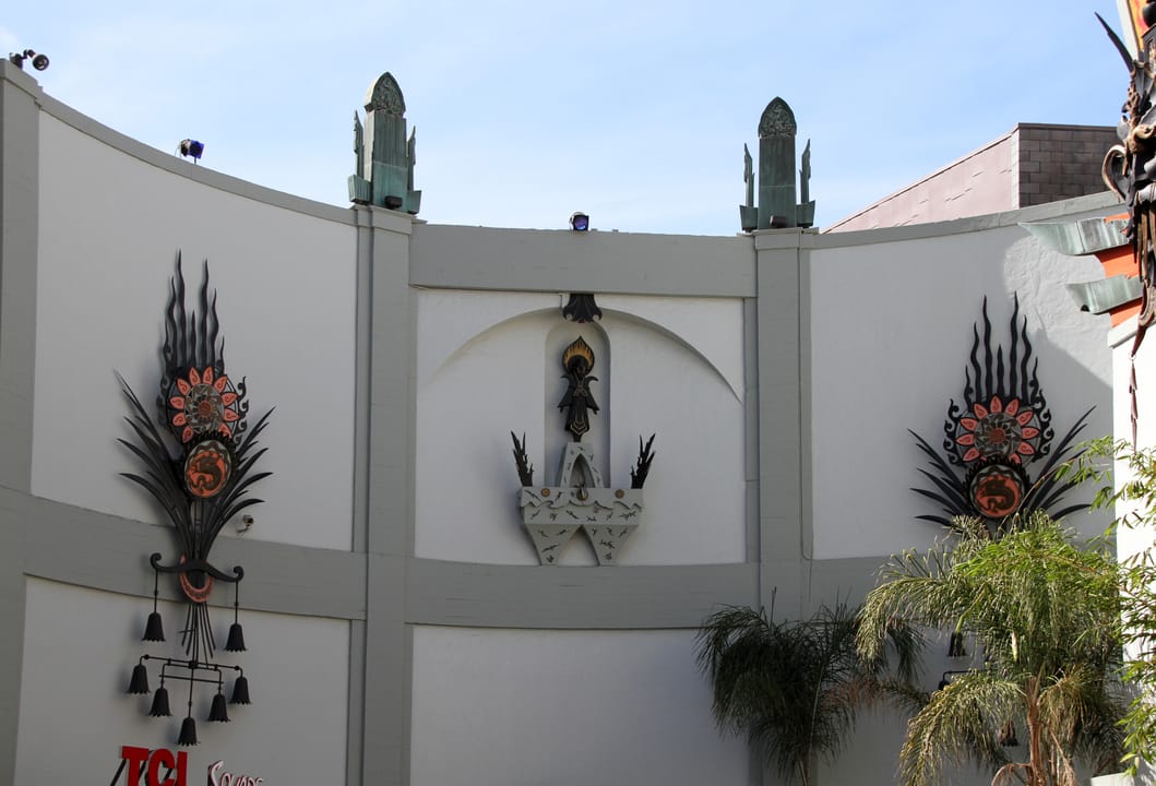 Detail of the curved wing wall beside the forecourt, with the theatre's bronze starburst wall ornaments, 2014.