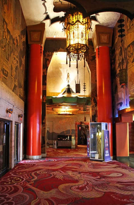 Red-carpeted entry hall with oriental mural panels, red lacquered columns and a hanging lantern, inside the Chinese Theatre lobby, 2014.