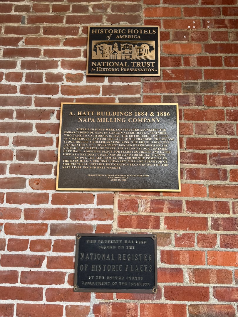 Historic marker at the Napa River Inn entrance, brick wall with signage in downtown Napa, California