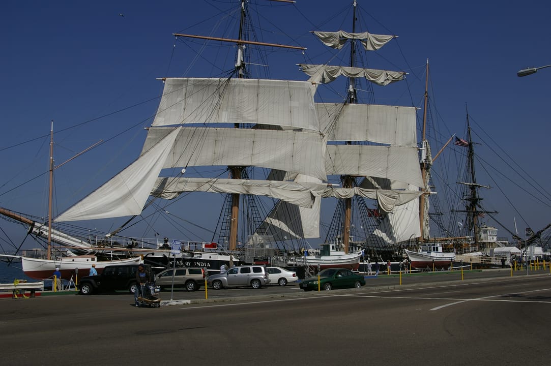The Star of India under full sail at her berth, broadside view with the downtown San Diego skyline behind, 2008.