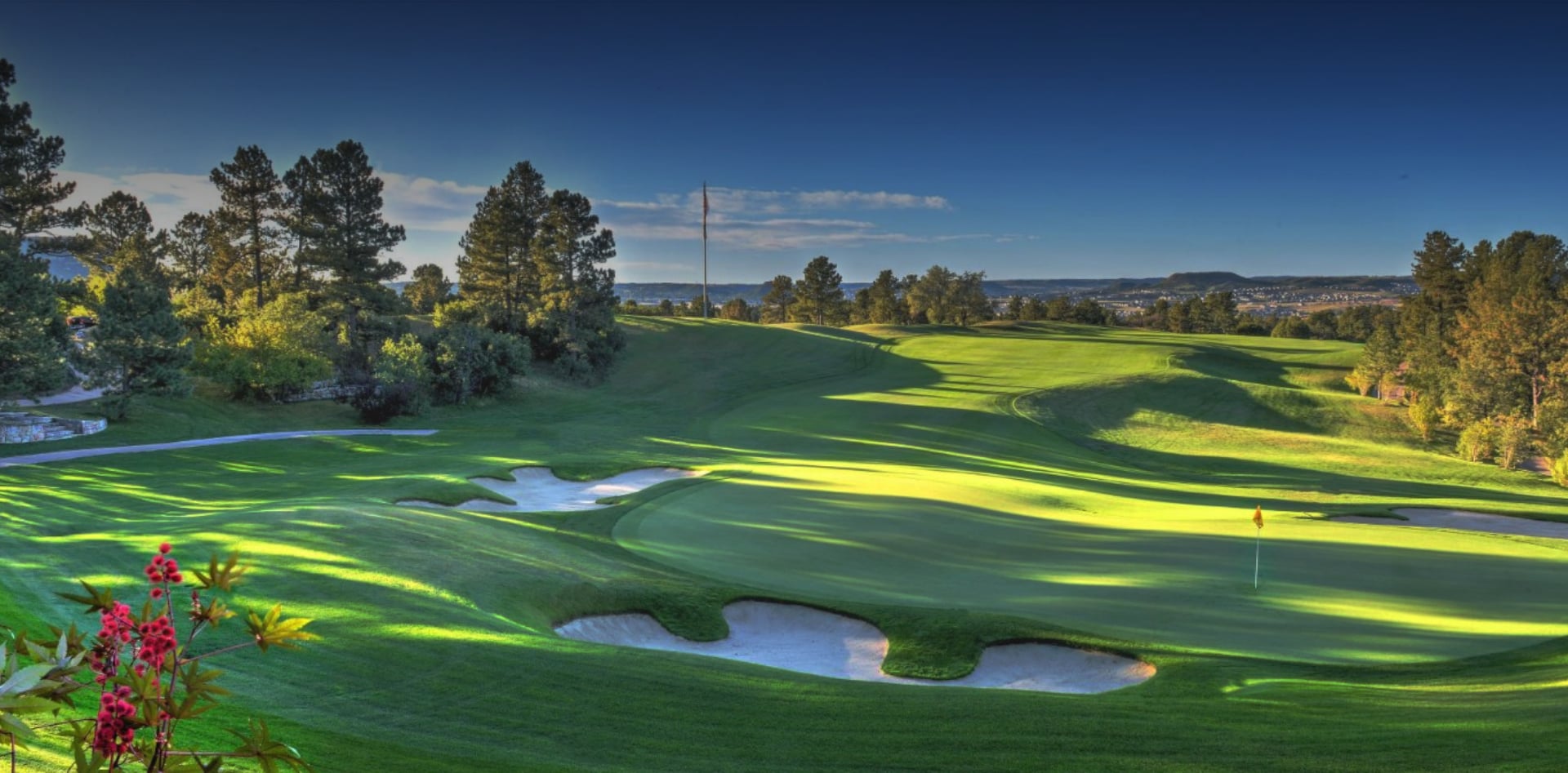 Mountain ridge and pine-edged fairway at the entrance to Castle Pines Golf Club