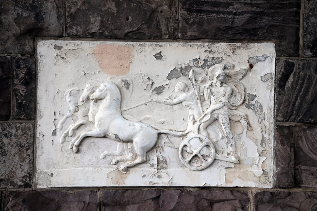 A carved stone bas-relief panel of a horse-drawn chariot set into the Molly Brown House's Richardsonian Romanesque exterior stonework, Denver, Colorado.
