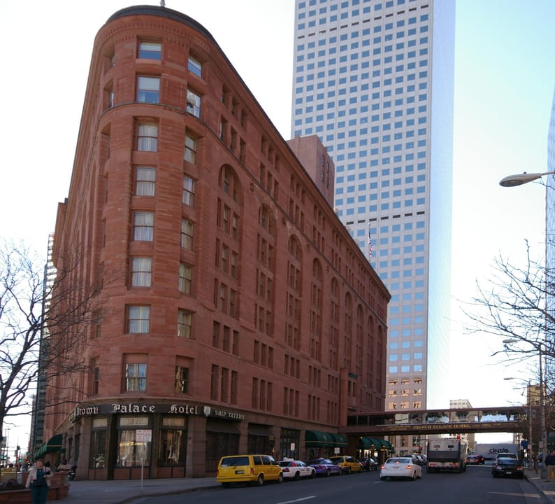 The Brown Palace Hotel's street-level corner entrance on 17th Street, Denver, with its awnings and ground-floor storefronts.