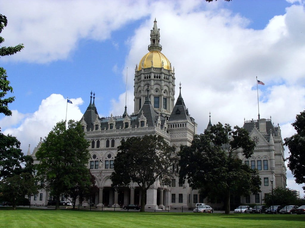 The marble and granite Victorian Gothic facade of the Connecticut State Capitol overlooking Bushnell Park in Hartford, Connecticut.