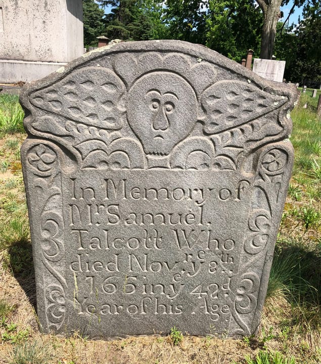 An elaborate marker of granite schist carved by Gershom Bartlett of Bolton Connecticut.  The stone is dated 1765 and is in the Old Wethersfield Village Cemetery.