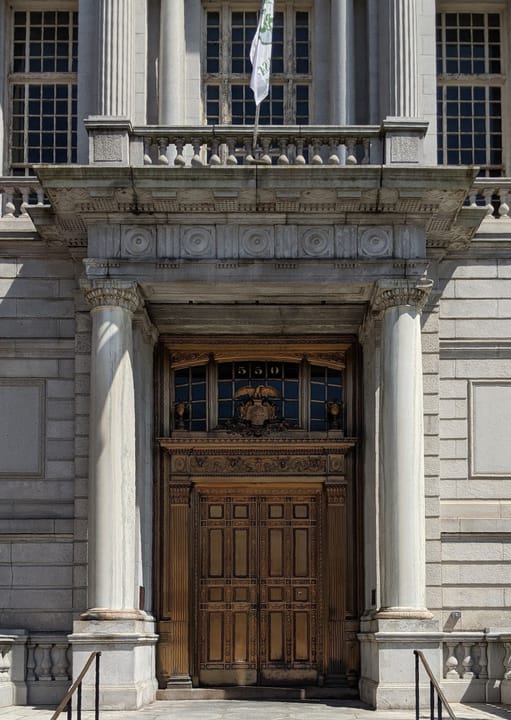 Close detail of the bronze entrance doors and stone portico of Hartford City Hall, 2020.