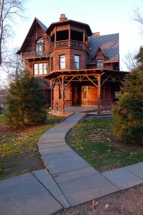 The front walkway leading to the turreted entrance porch of the Mark Twain House, Hartford, Connecticut, in late-afternoon light