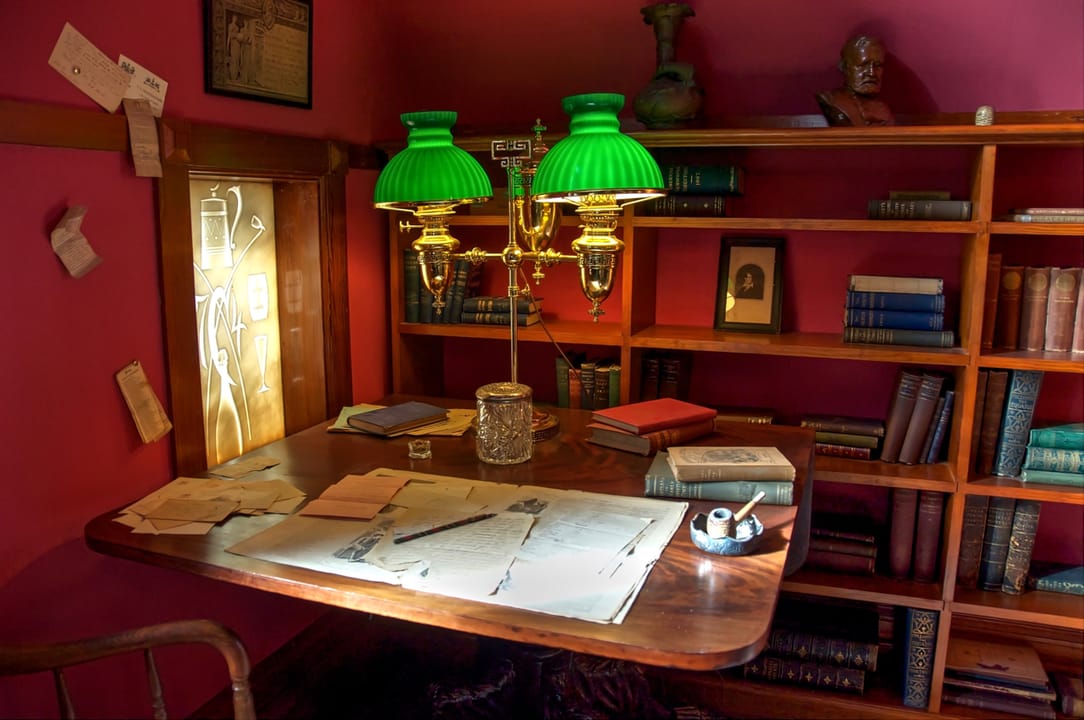 Mark Twain's study, with the green-shaded desk lamp and built-in bookshelves, inside the Mark Twain House museum