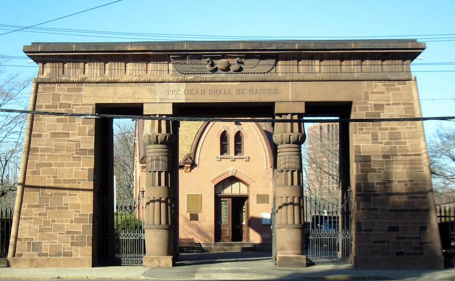 Egyptian Revival 1845 brownstone gateway of Grove Street Cemetery in New Haven, Connecticut, inscribed 'The Dead Shall Be Raised,' designed by Henry Austin.