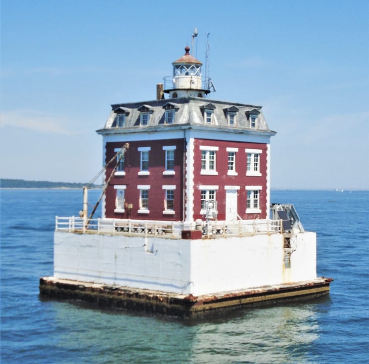 New London Ledge Lighthouse viewed straight-on from the water in daylight, 2022, showing the full ledge platform and brick keeper's house.