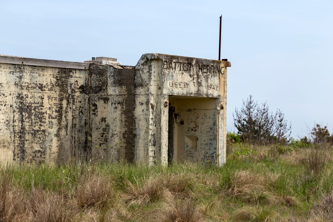 Battery Herring, a weathered WWII coastal-defense bunker at Fort Miles, with its 1942 US Army inscription still visible over the entrance.