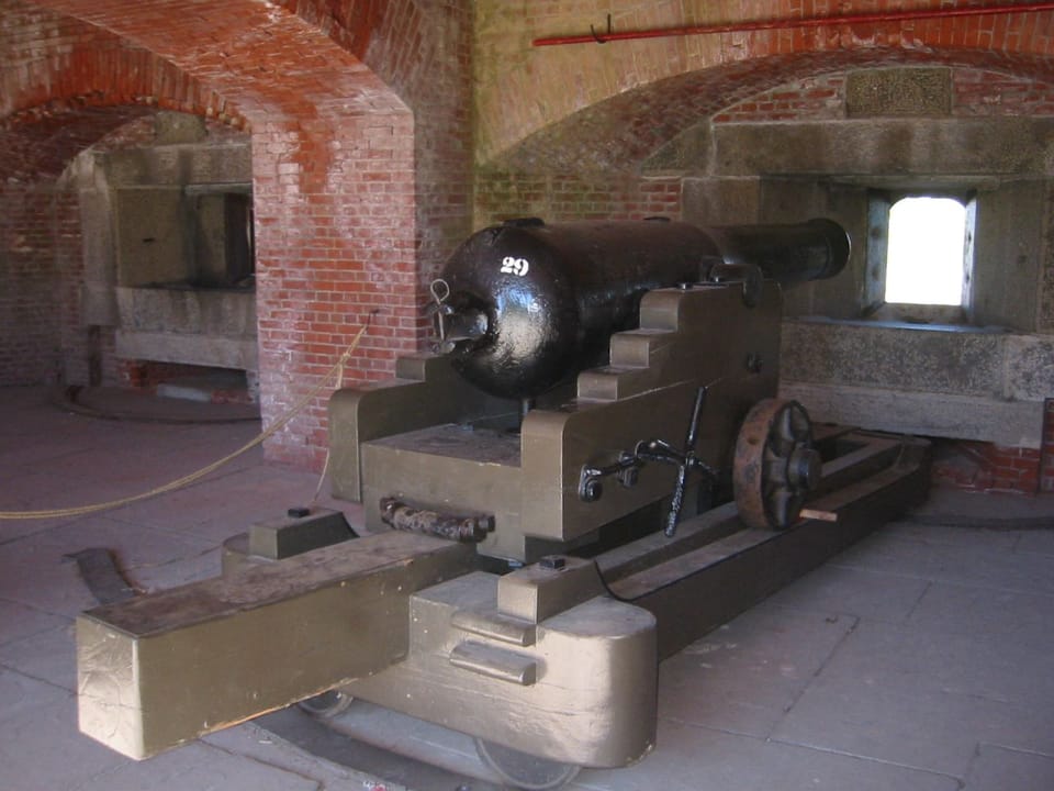 A cannon mounted inside one of Fort Delaware's brick casemates, aimed through a gun port (2007).