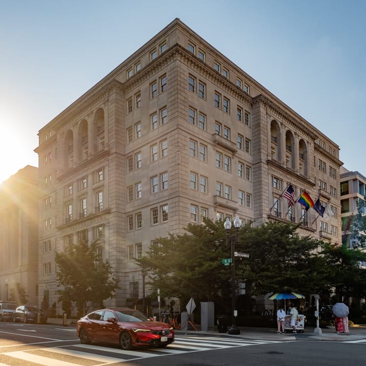 Street-level view of the Hay-Adams Hotel with flags flying along the facade, Washington, D.C. (2024).