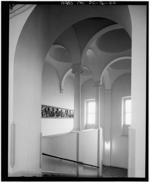 The arched colonnade of the Pension Building's south stairwell landing, with the building's terra-cotta frieze visible below the window, HABS photograph.