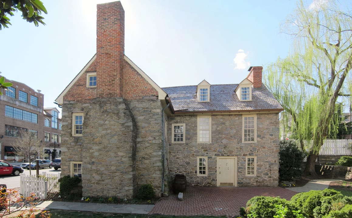 A panorama of the Old Stone House's east side, showing the chimney, rear kitchen door and the garden steps, with M Street at the far left.