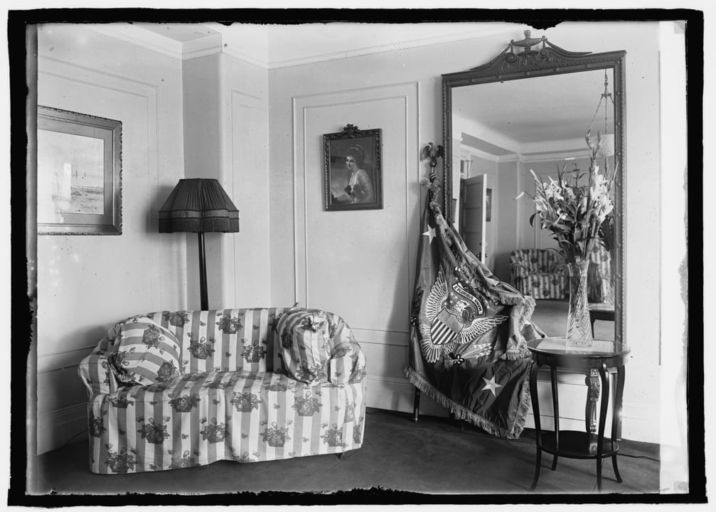A guest sitting room at the Willard Hotel, furnished with a striped sofa and wing chairs, August 5, 1923.