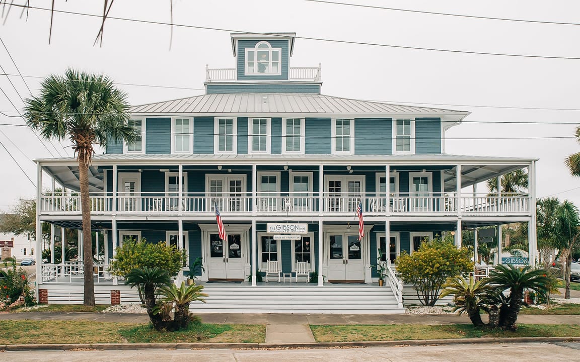 Exterior of the historic Gibson Inn, a three-story Victorian wood-frame inn in the Apalachicola Historic District, Florida