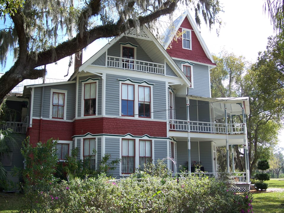 Close view of the May-Stringer House's red-trimmed upper story and screened porch, Brooksville, Florida.