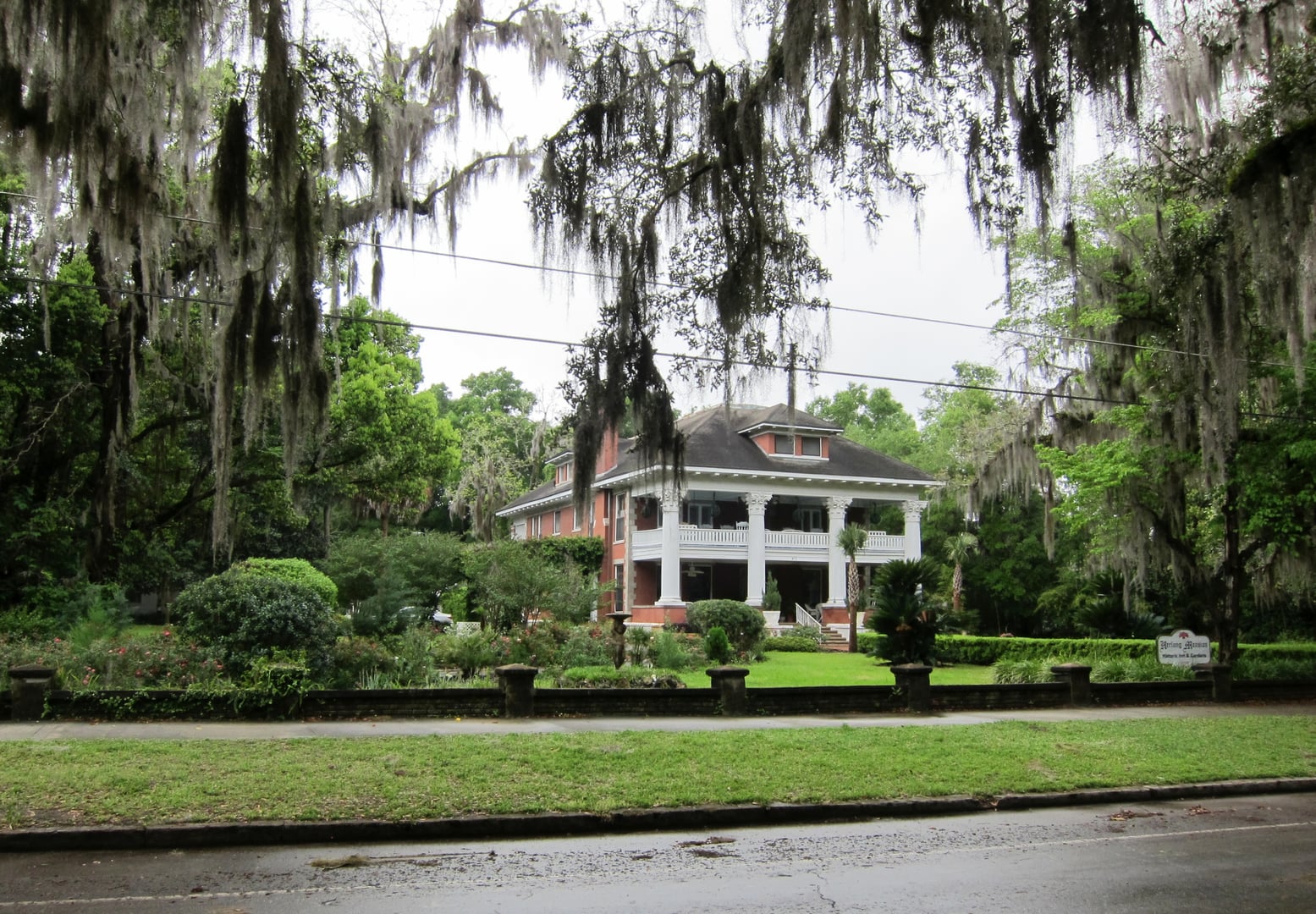 The Herlong Mansion's white Greek Revival facade with four full-height Corinthian columns in Micanopy, Florida