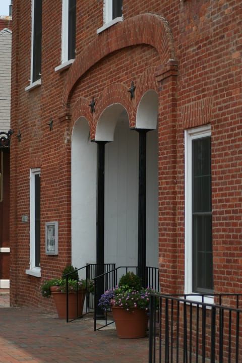 The arched brick entrance of the Kennesaw House in Marietta, Georgia, with three white arches on black columns, white-trimmed windows and star-shaped wall anchors, in August 2007.