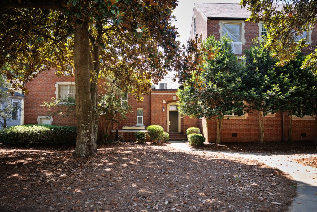 Boone Hall at Mercer University in Macon, Georgia — a brick residence hall with arched doorway and symmetrical windows shaded by mature trees