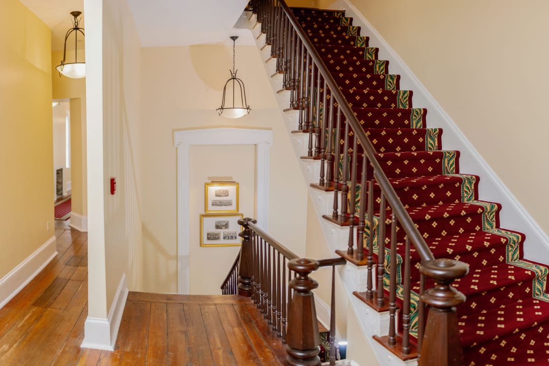 Main staircase inside The Marshall House, Savannah, with red stair runner.