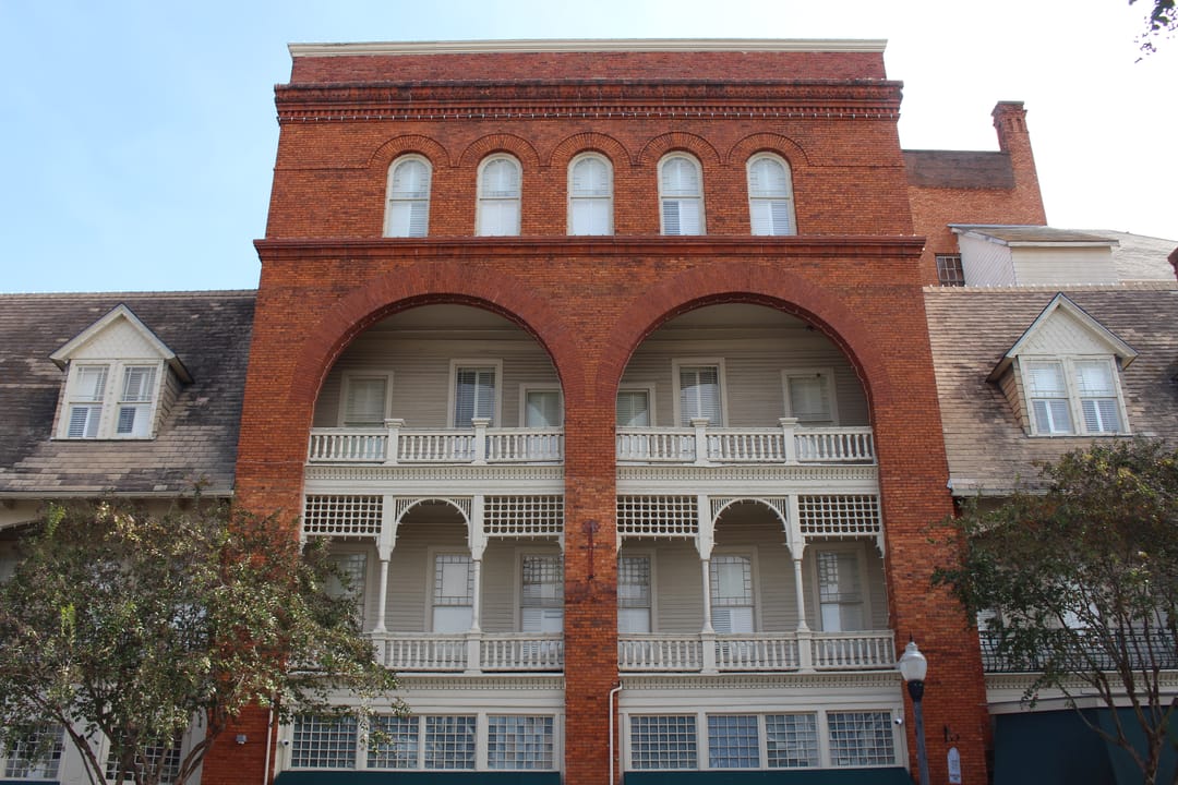 Close view of the Windsor Hotel's brick arcade and iron balconies on North Jackson Street, Americus, Georgia.