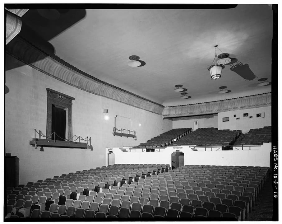 The Egyptian Theatre's auditorium seen from the rear, looking toward the screen past rows of original seating and the balcony front.