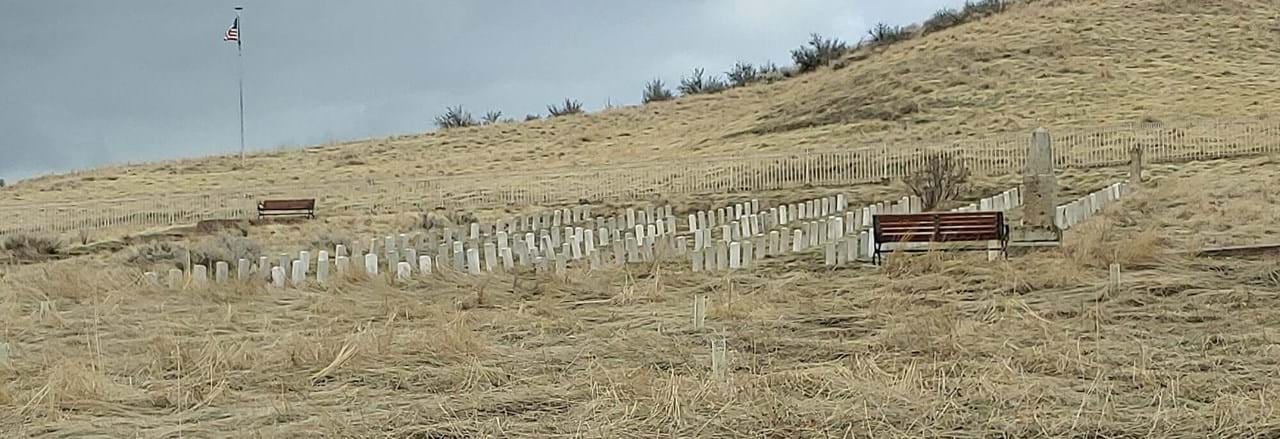 Fort Boise Military Cemetery at the mouth of Cottonwood Canyon in the Boise Foothills, with weathered military headstones and a flagpole