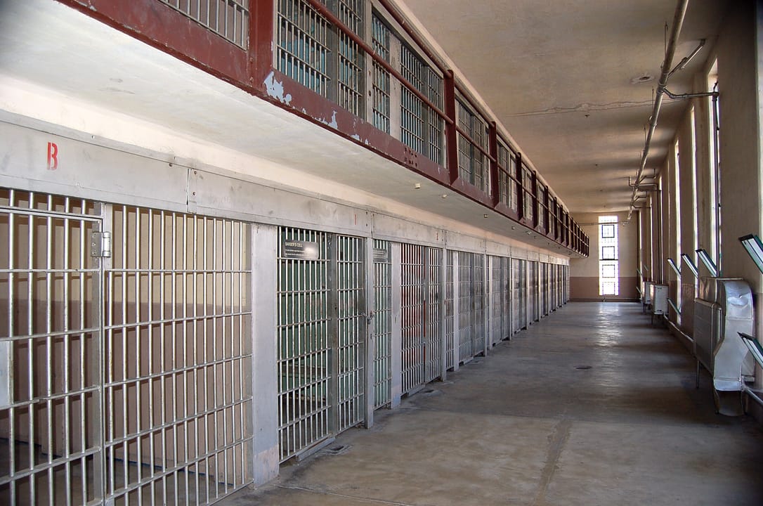 Long cellblock corridor inside 4 House at the Old Idaho State Penitentiary, Boise, Idaho, lined with barred cells.