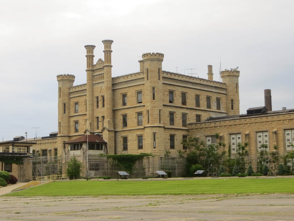 The full front facade of Old Joliet Prison viewed across its lawn, Joliet, Illinois.