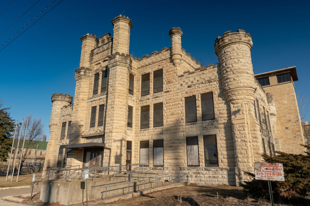 The weathered front office building of Old Joliet Prison, with boarded windows, Joliet, Illinois.