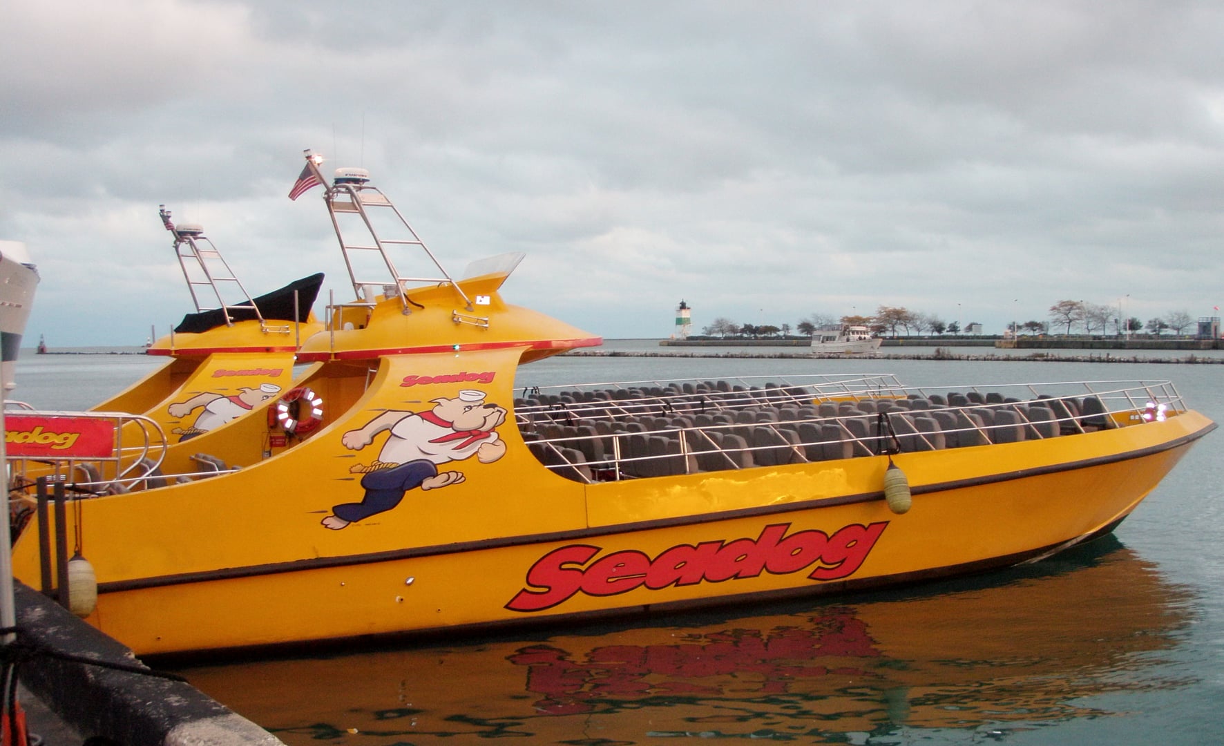 A Seadog speedboat on the Chicago River at twilight with the Loop skyline visible above