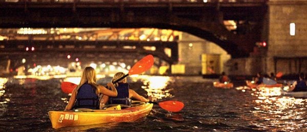 Kayakers on the Chicago River at dusk during a Wateriders Ghosts & Gangsters evening tour