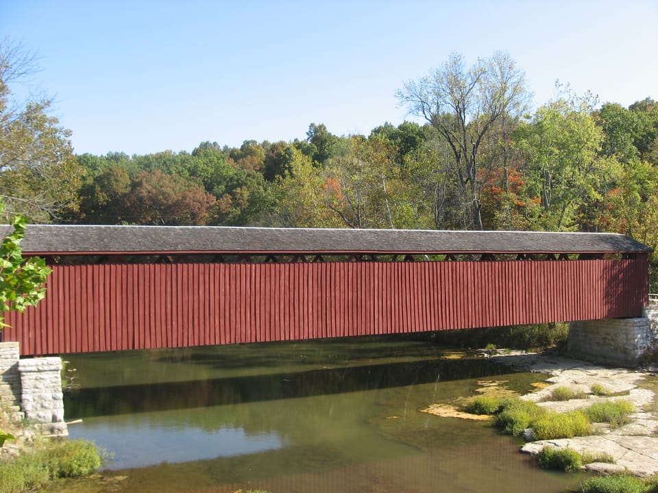 Southern (downstream) side of the Cataract Covered Bridge, which spans the White River near Cataract in Jennings Township, Owen County, Indiana, United States.  Built in 1876, it is listed on the National Register of Historic Places.