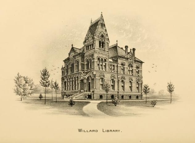 Front and southern side of the Victorian Gothic Willard Library building, clear daylight, full facade with central gable, corner tower and ornamented brick and stonework, 2011.
