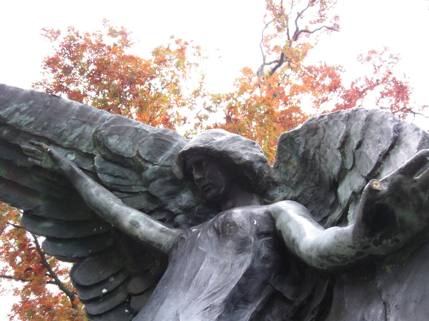 The bronze Black Angel monument towering over headstones at Oakland Cemetery in Iowa City, Iowa