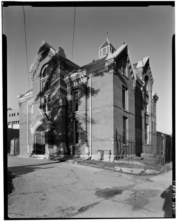 View of the Pottawattamie Squirrel Cage Jail from the northwest, Council Bluffs, Iowa, photographed for the Historic American Buildings Survey in 1977, showing the building's rear corner and roof dormers.