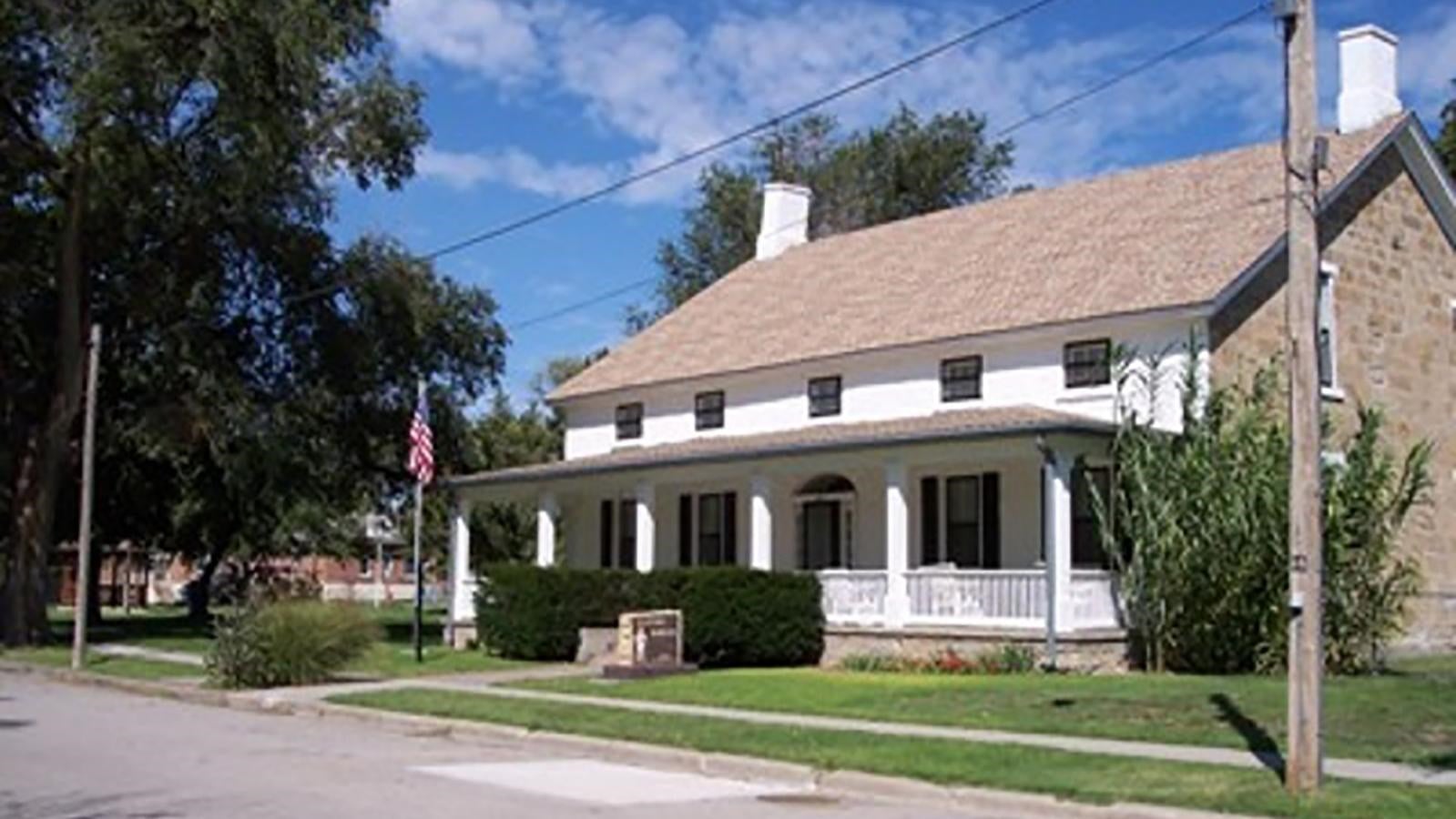Historic two-story building with white porch at Fort Dodge, Kansas — the original 1865 military post five miles east of Dodge City now operating as the Kansas Soldiers' Home