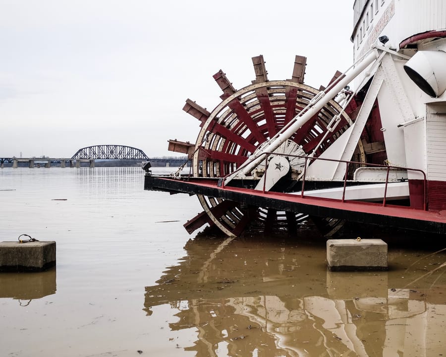 Detail of the Belle of Louisville's red stern paddlewheel reflected in low Ohio River water, March 12, 2019.
