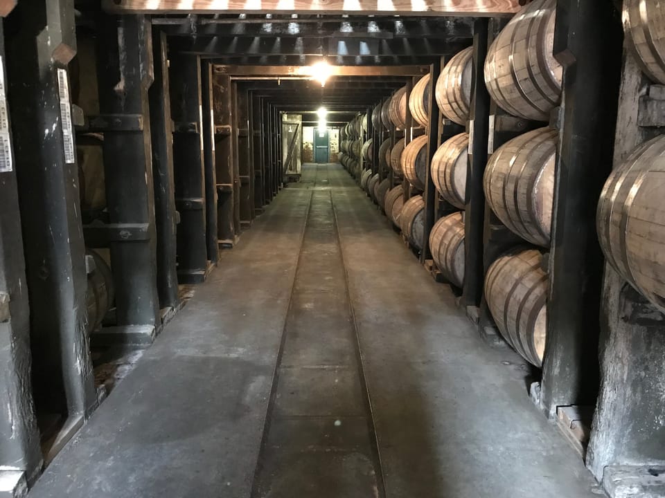 The interior of a barrel aging warehouse at Buffalo Trace Distillery, rows of bourbon barrels stacked along a rickhouse corridor, Frankfort, Kentucky.