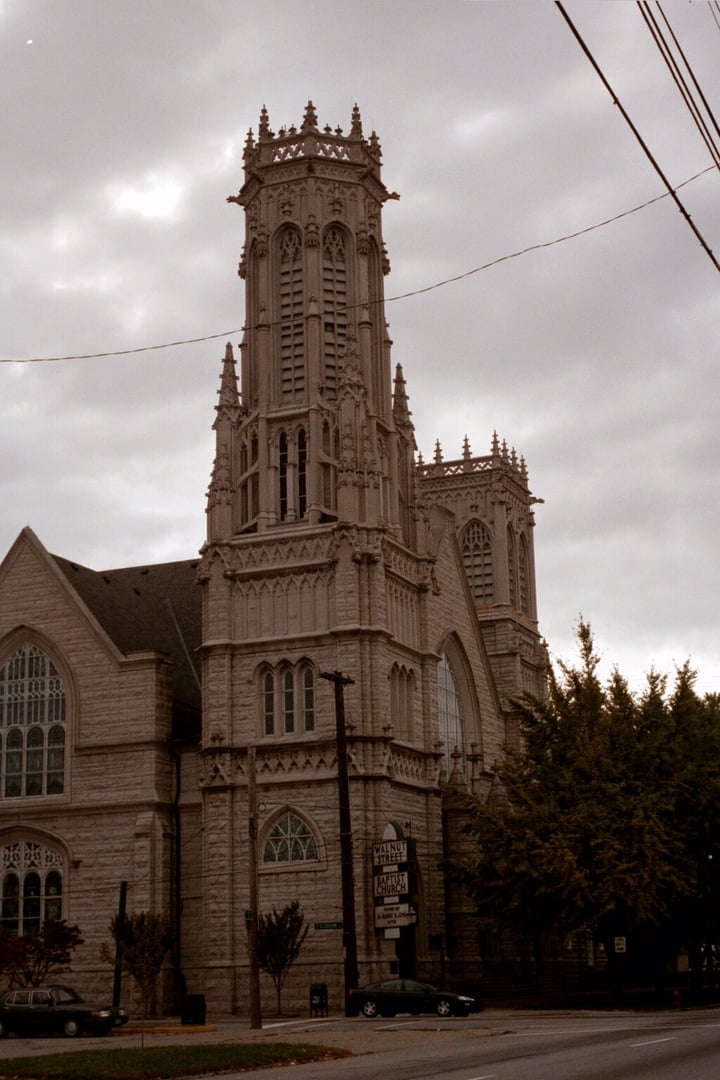 Gothic Revival corner tower and gargoyle-lined ledges of Walnut Street Baptist Church at S. 3rd and St. Catherine in Old Louisville